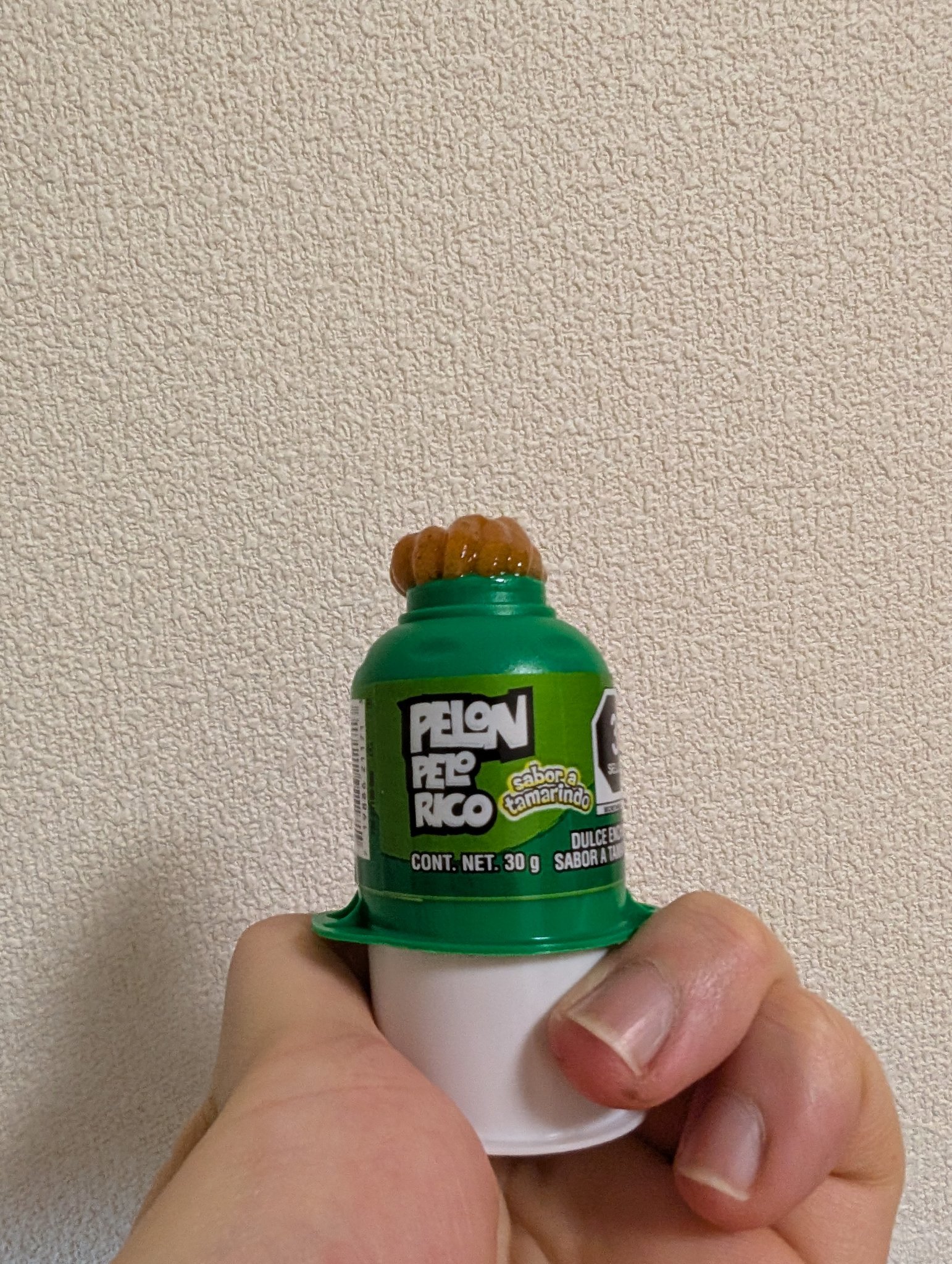 一個叫 Pelon Pelo Rico 的糖果。有一個綠色的小罐子,下面有一個長長的圓柱狀的東西可以推進去,就可以從上面推出深橘色的半固狀糖果